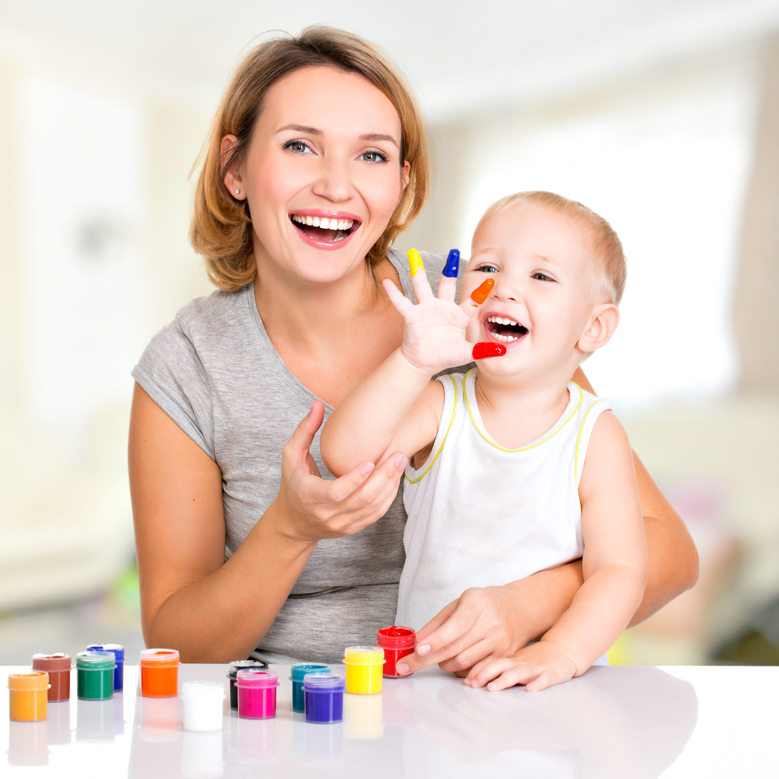 Happy young mother and child with painted hands. kids with colors
